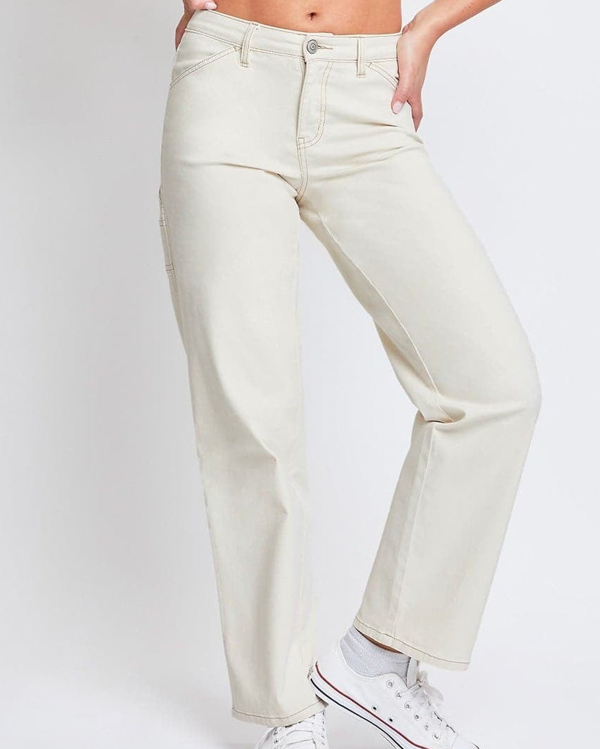 Woman wearing a beige crop top and light-colored pants on a white background