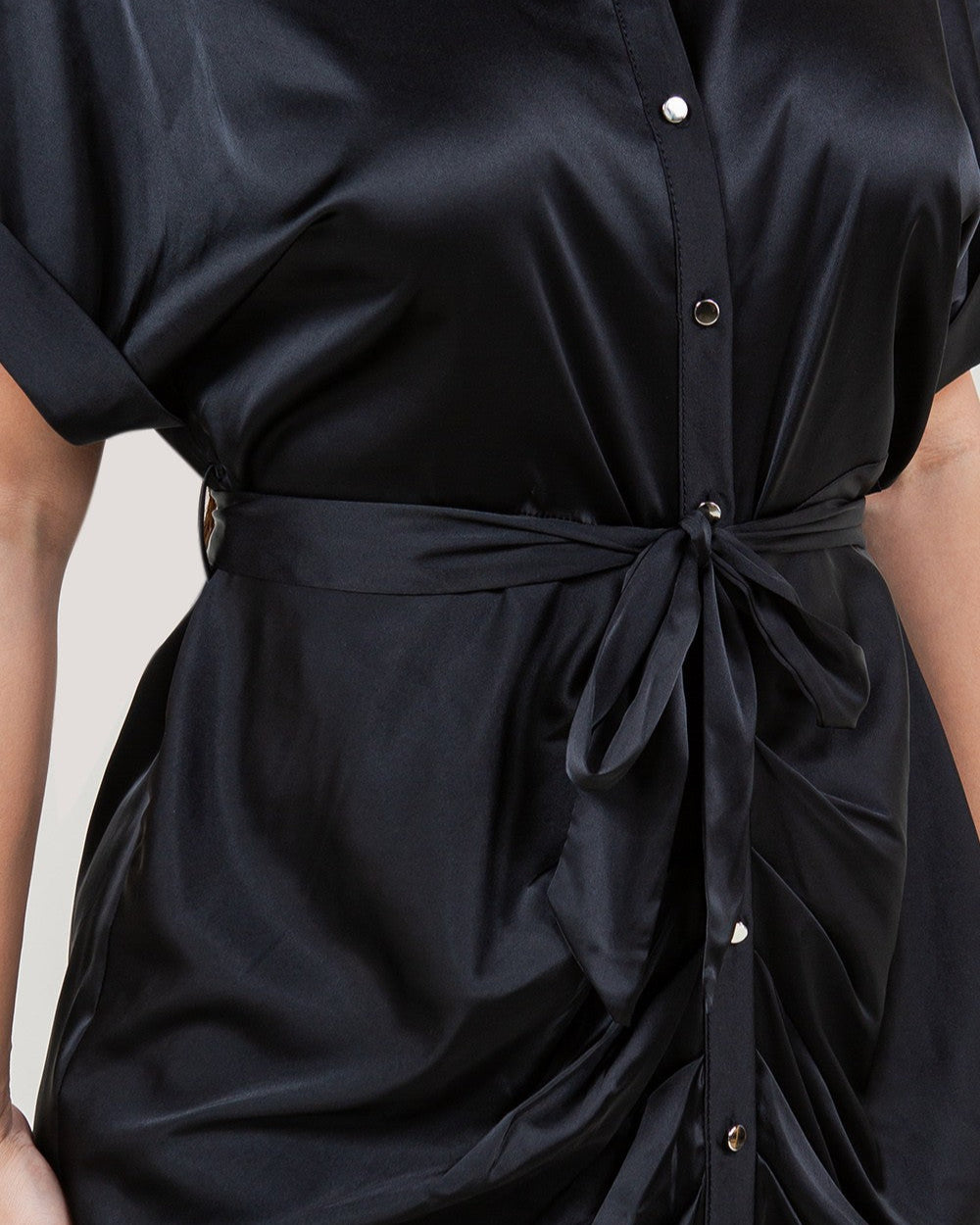 Black dress with a tie waist on a neutral background