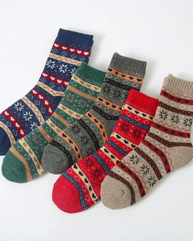Four pairs of patterned knit ankle socks arranged diagonally on a plain white background. The socks feature traditional Nordic/Fair Isle motifs in various colorways including navy, green, gray, red, and beige.