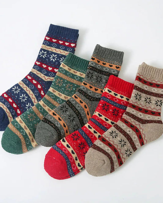 Four pairs of patterned knit ankle socks arranged diagonally on a plain white background. The socks feature traditional Nordic/Fair Isle motifs in various colorways including navy, green, gray, red, and beige.