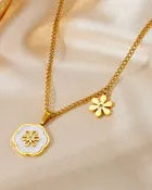 Gold necklace with a floral pendant on a soft beige background