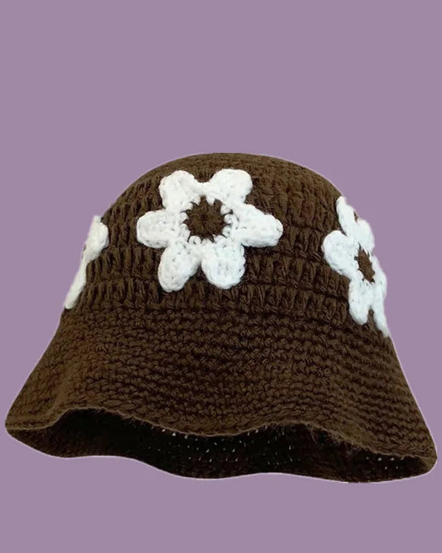 Brown crochet hat with white flowers on a purple background