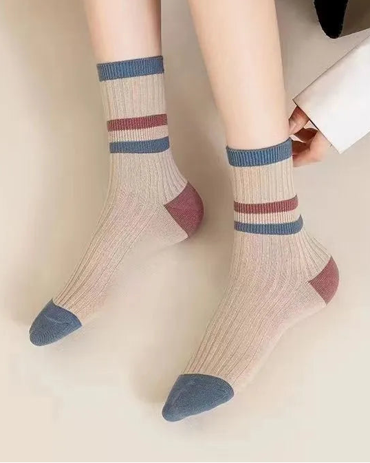 Person wearing striped socks with a neutral background