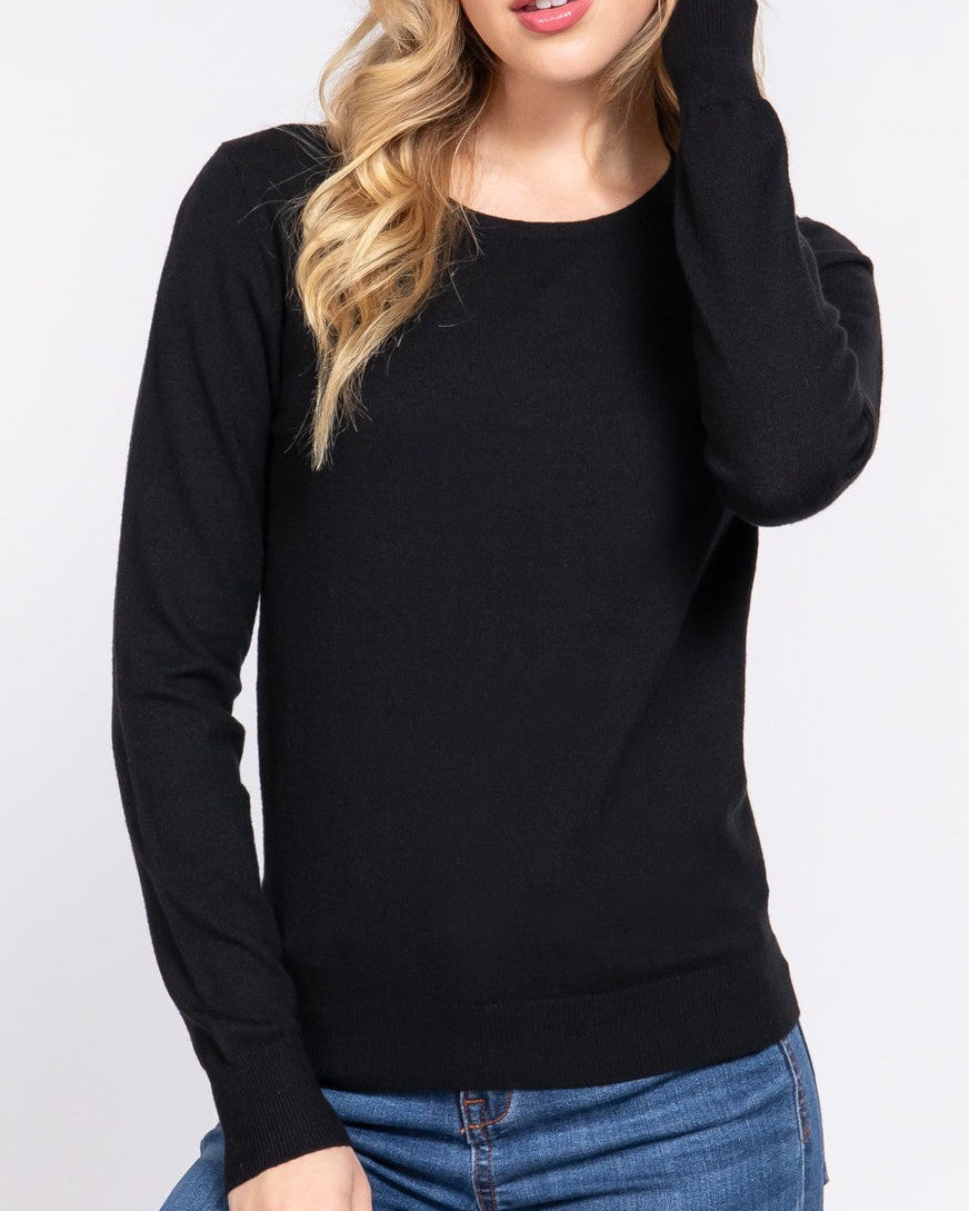 Woman wearing a black sweater and blue jeans on a white background