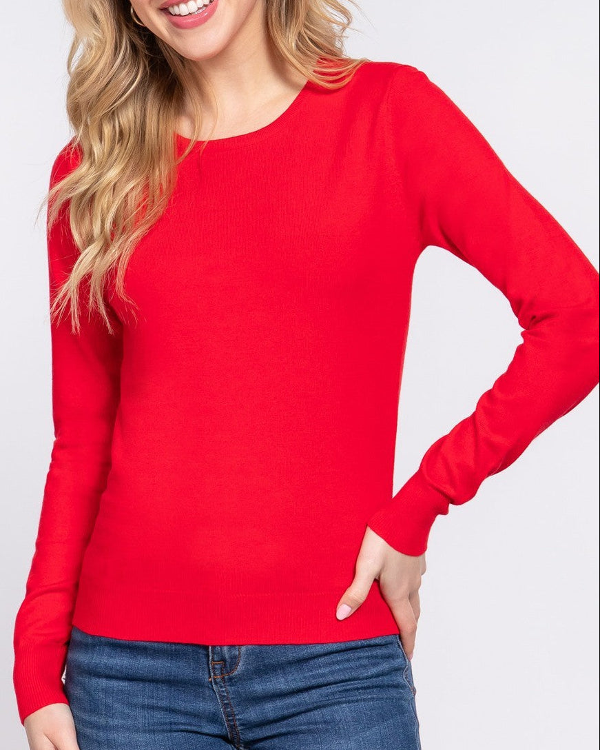 Woman wearing a red sweater and blue jeans on a white background