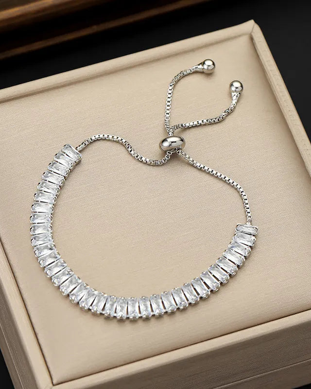 Silver bracelet with clear stones on a beige jewelry box