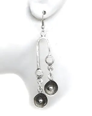 Silver earrings on a white mannequin ear