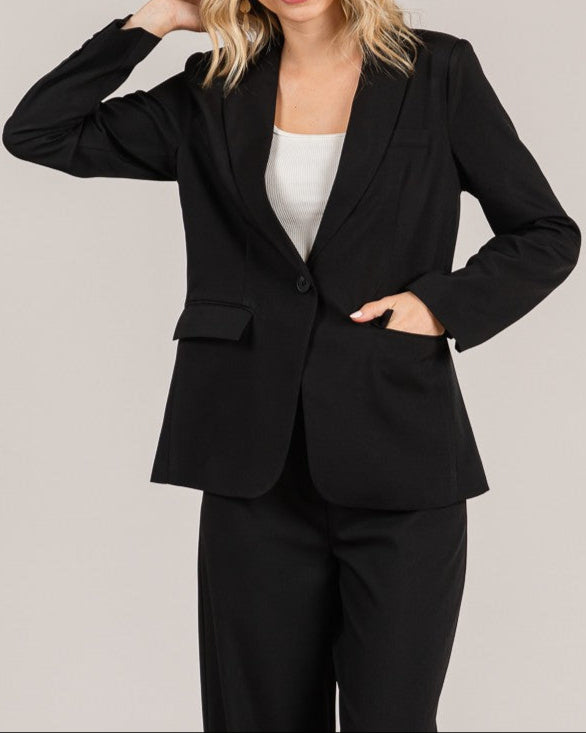 Woman wearing a black suit with a plain background