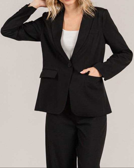 Woman wearing a black suit with a plain background