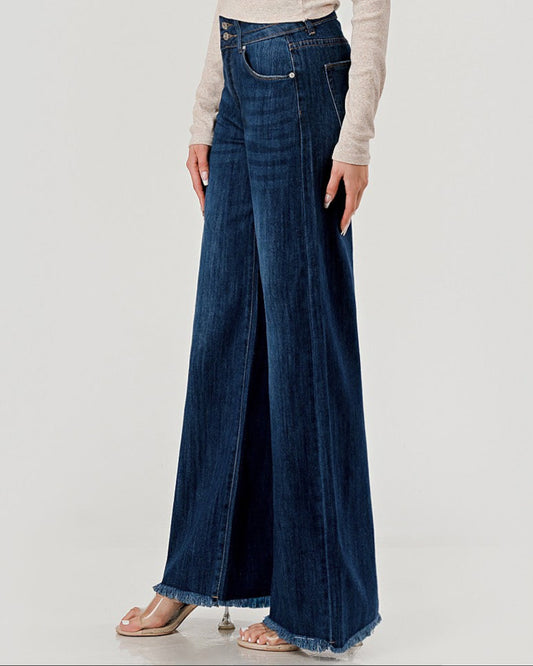 Long blue denim jeans worn by a person on a light gray background