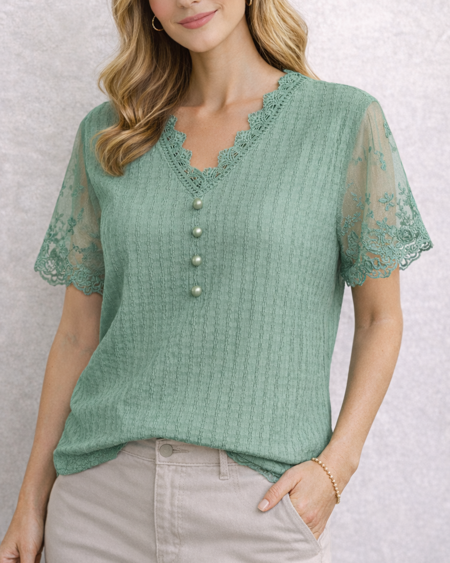 Woman wearing a green lace top with a textured pattern on a light background