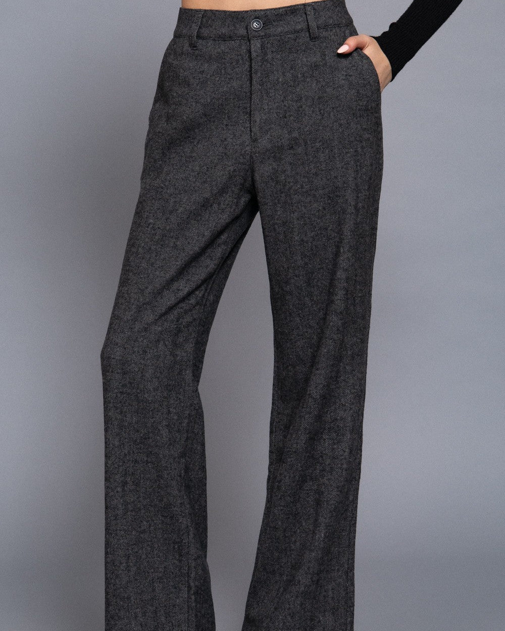 Dark gray flared pants on a gray background