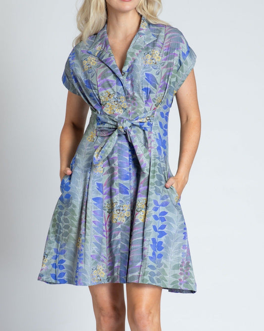 Woman wearing a floral dress with a plain background