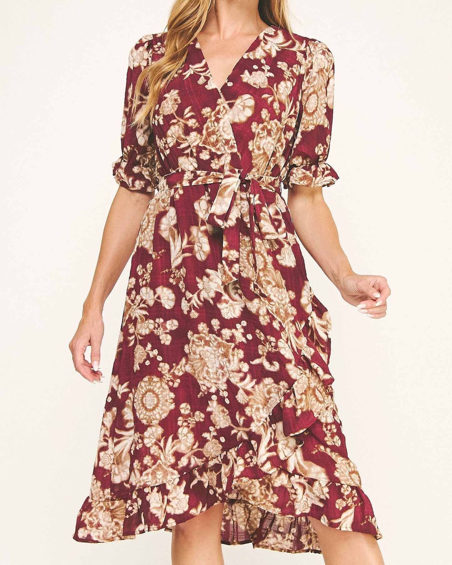 Woman wearing a burgundy floral dress on a white background