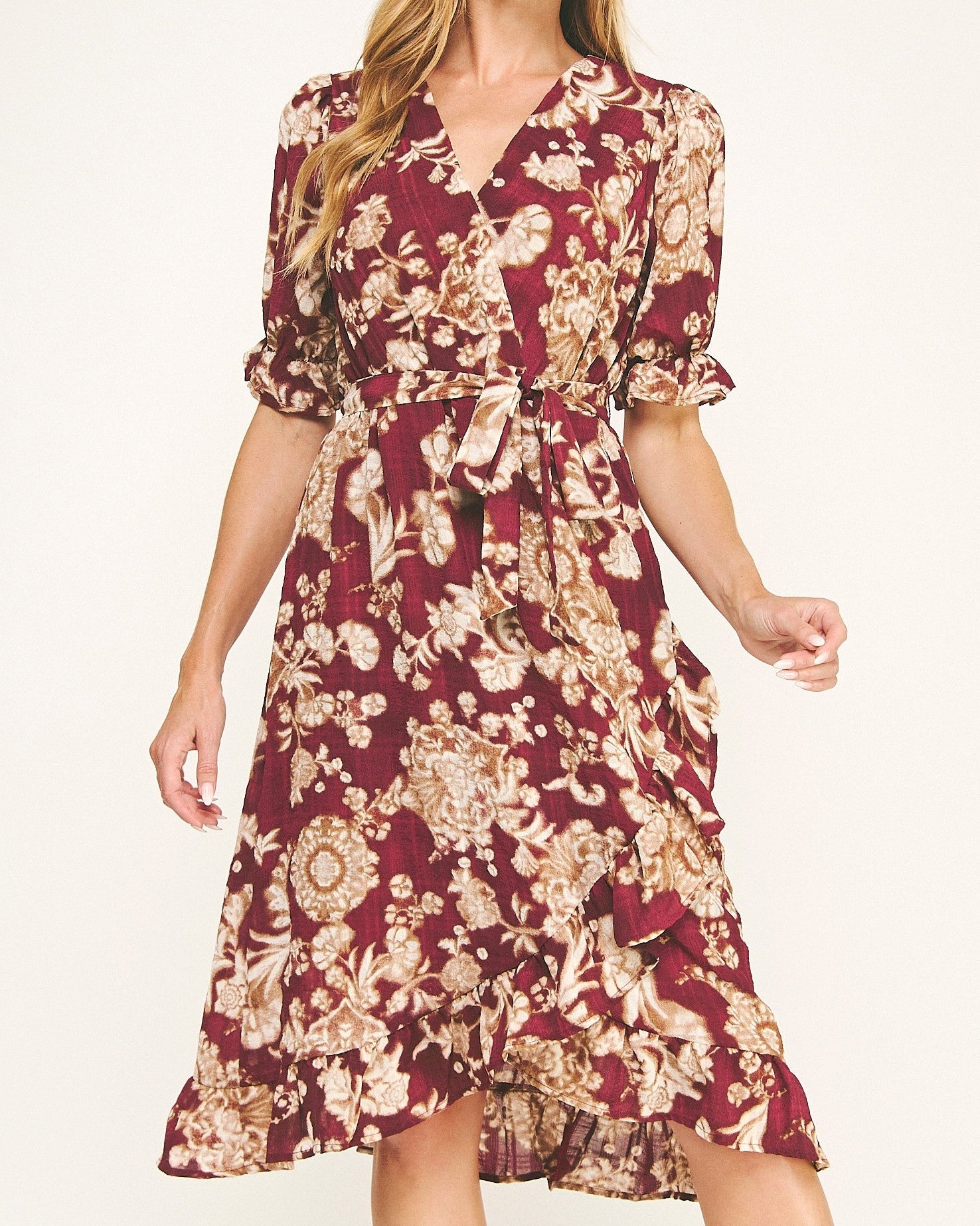 Woman wearing a burgundy floral dress on a white background
