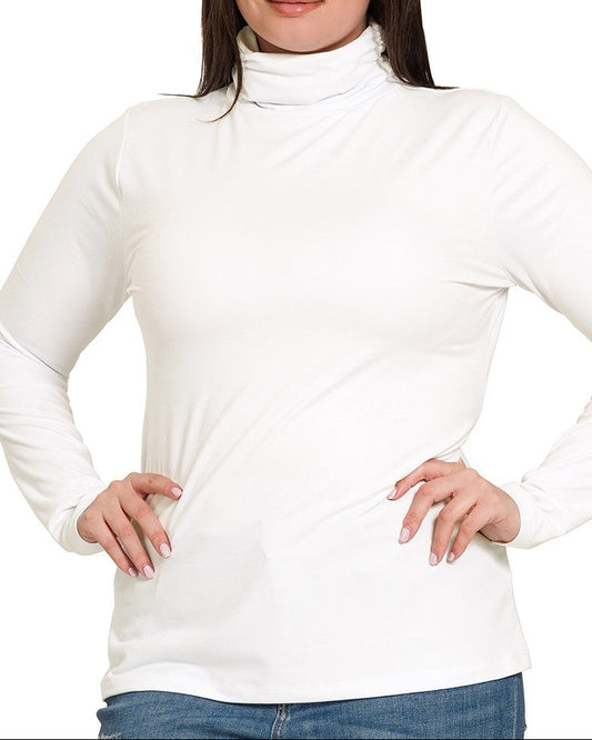 Woman wearing a white turtleneck sweater with blue jeans on a white background