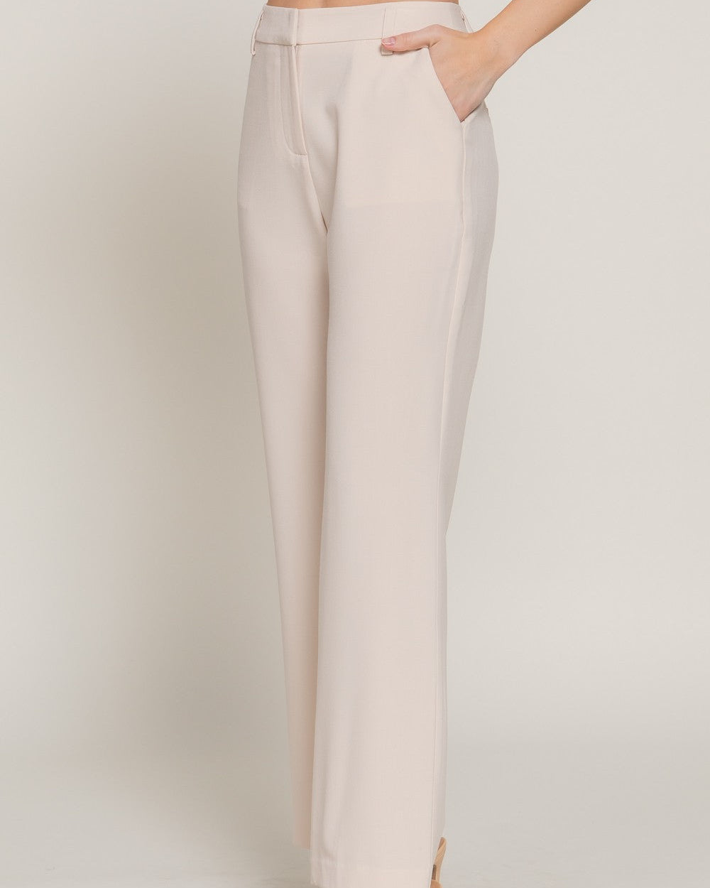 Beige pants worn by a person on a plain background