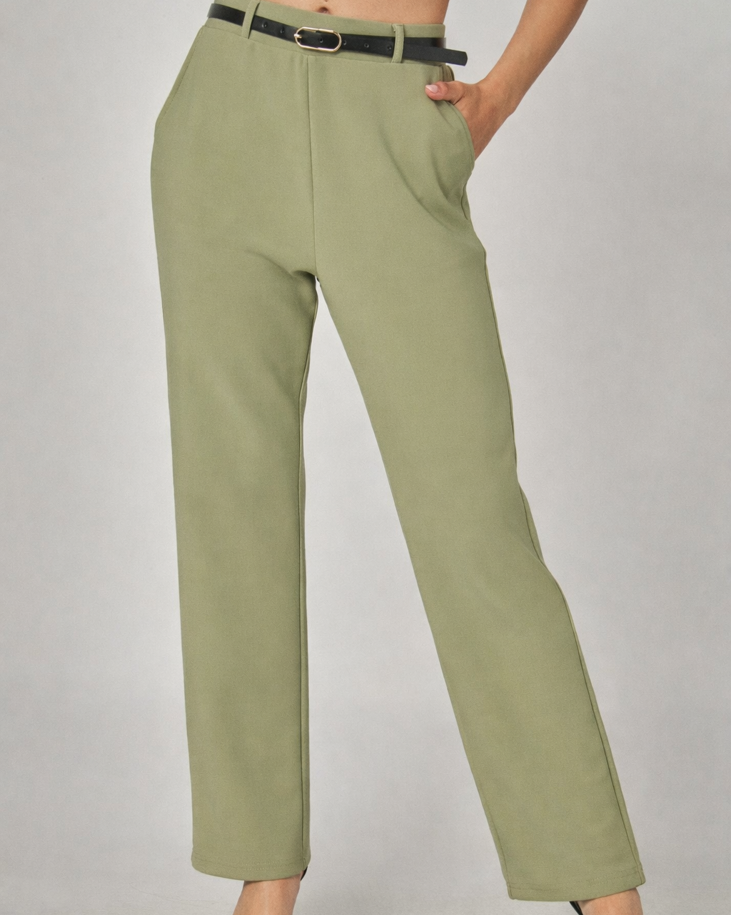 Green pants worn by a person on a plain background