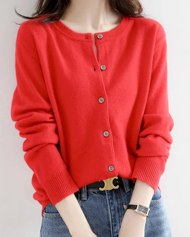 Red cardigan worn by a person on a plain background