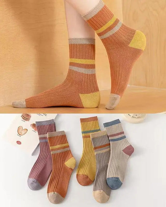 Colorful striped socks on a wooden floor with a close-up of multiple pairs on a white background.