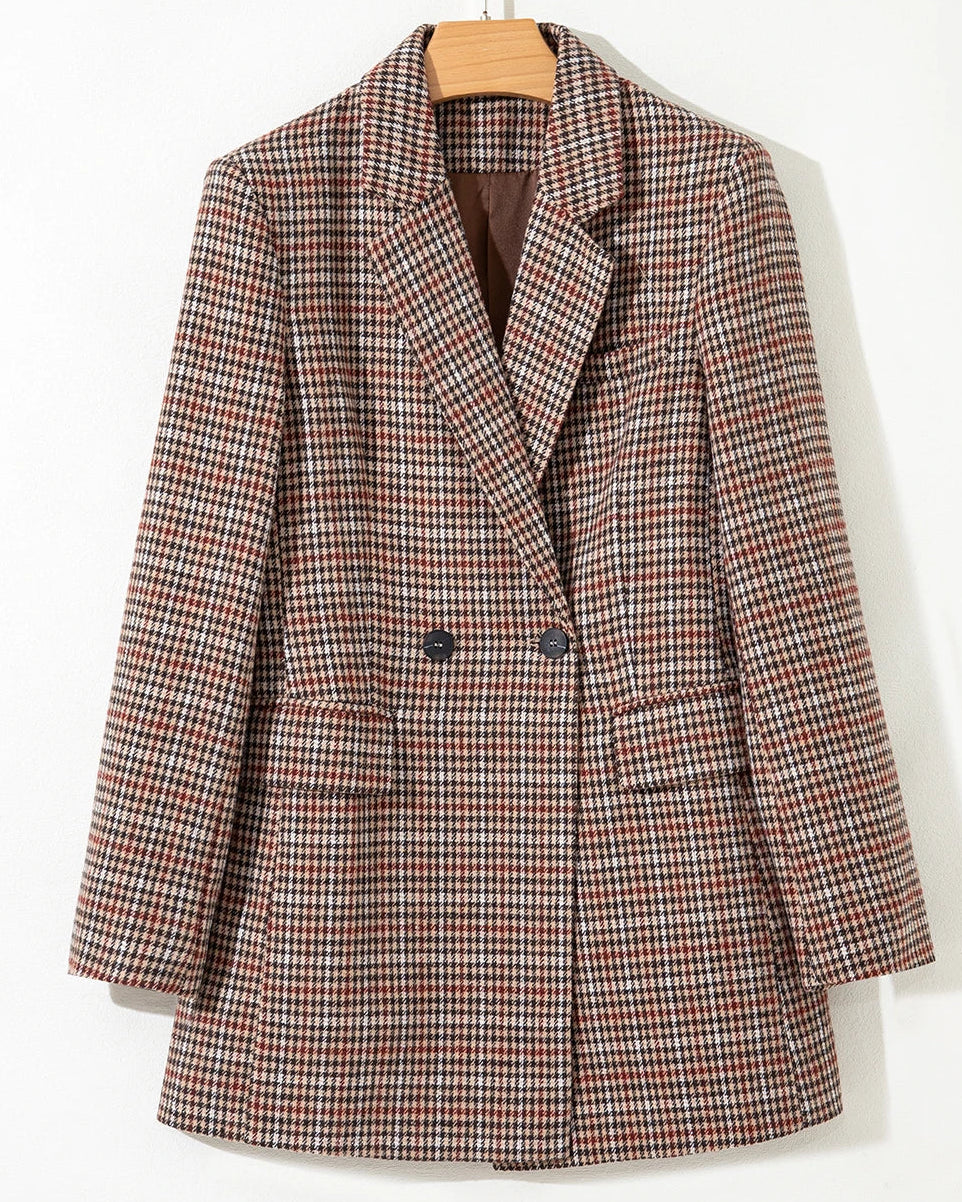 Plaid blazer on a hanger against a white background