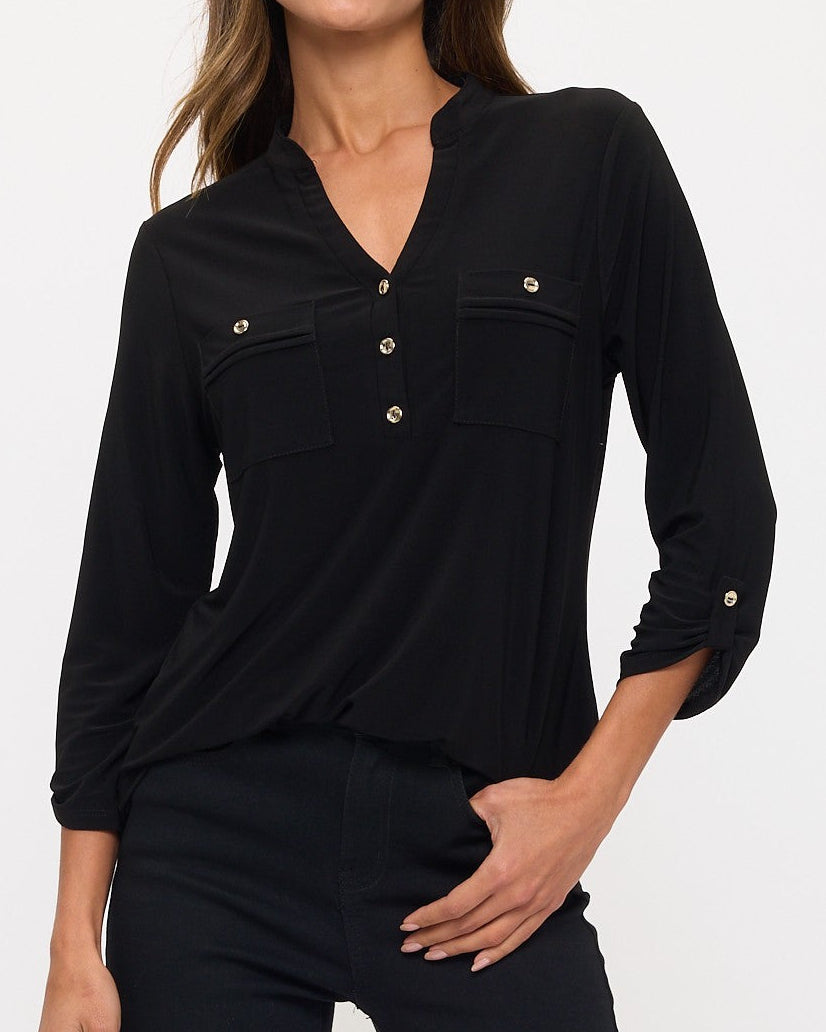 Woman wearing a black long-sleeve top with button details on a white background