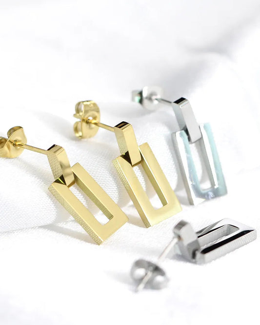 Gold and silver geometric earrings on a white background