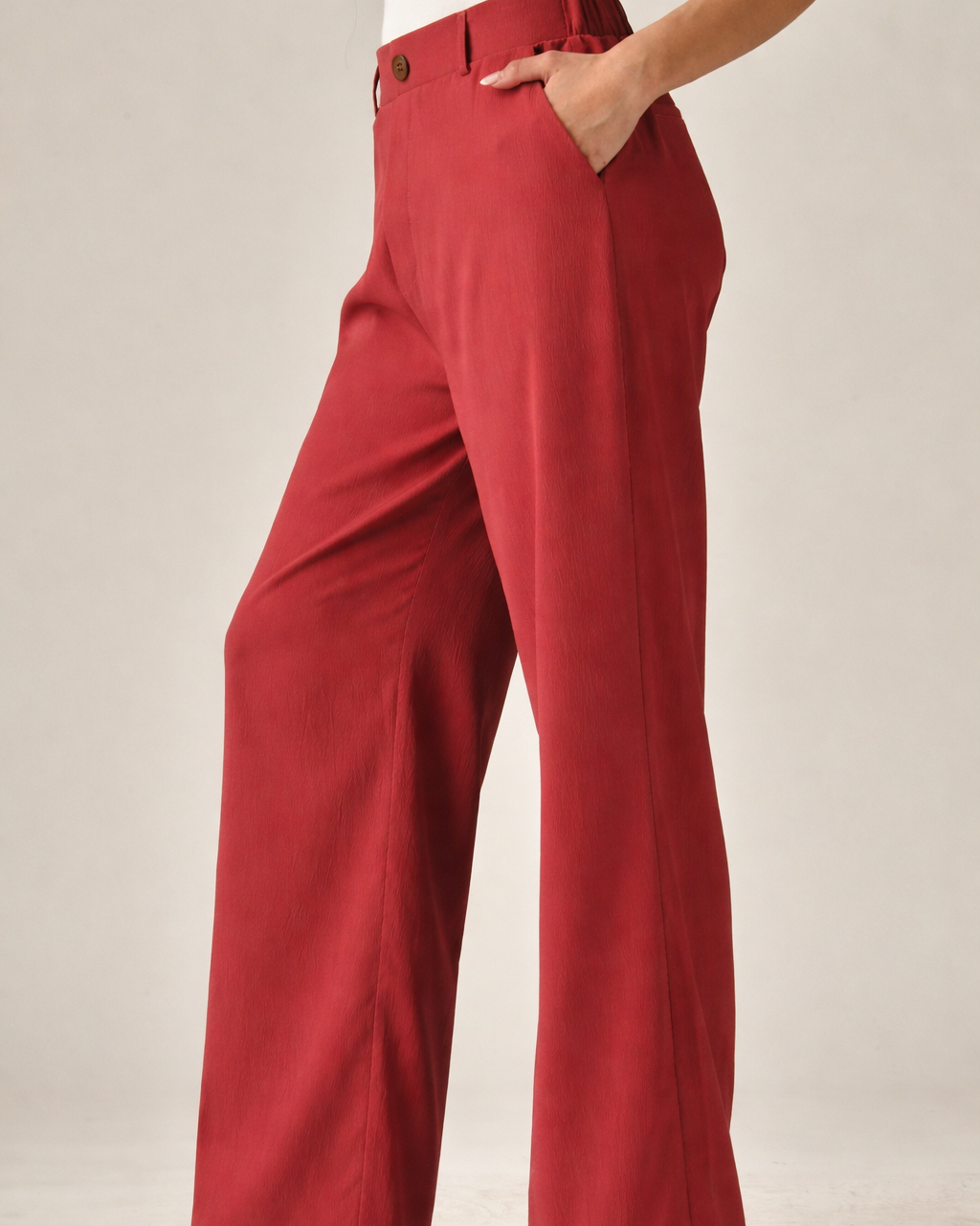 Red pants worn by a person on a plain background