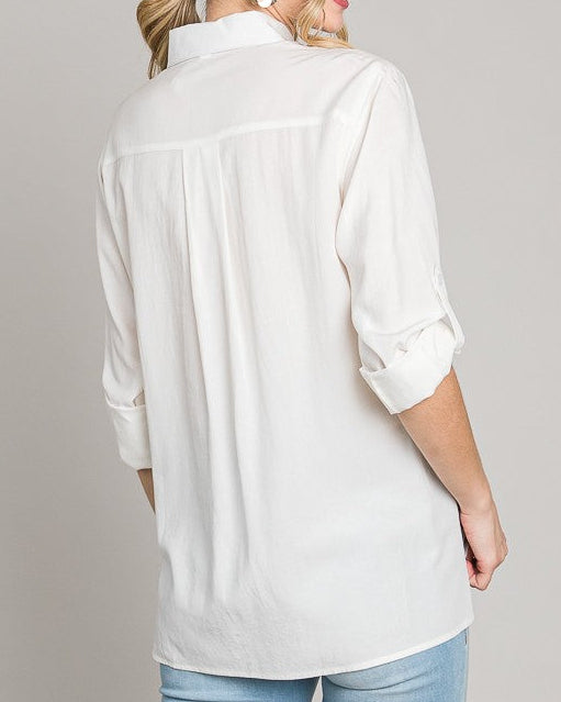 Woman wearing a white blouse and light blue jeans on a plain background