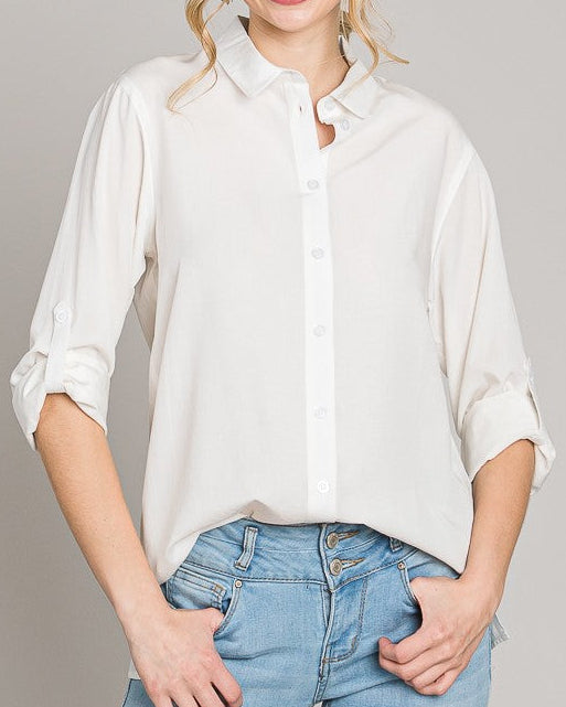 Woman wearing a white blouse and blue jeans on a gray background
