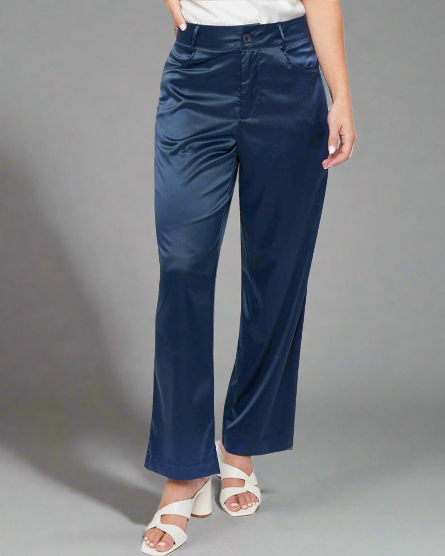 Woman wearing a white top and navy pants on a white background