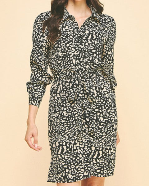Woman wearing a black and white patterned dress on a beige background