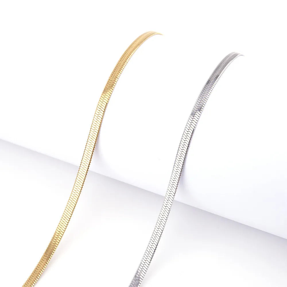 Gold and silver snake chain necklaces on a white background