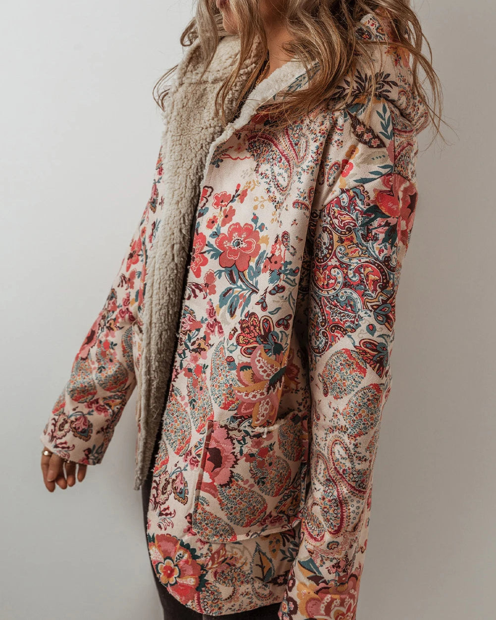 Person wearing a floral patterned jacket against a plain background