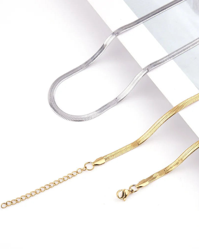 Gold and silver chain necklaces on a light gray background