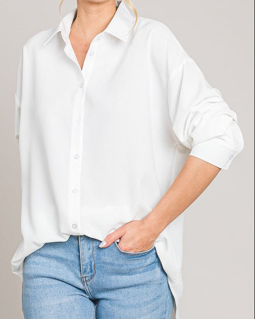 Woman wearing a white shirt and blue jeans against a plain background
