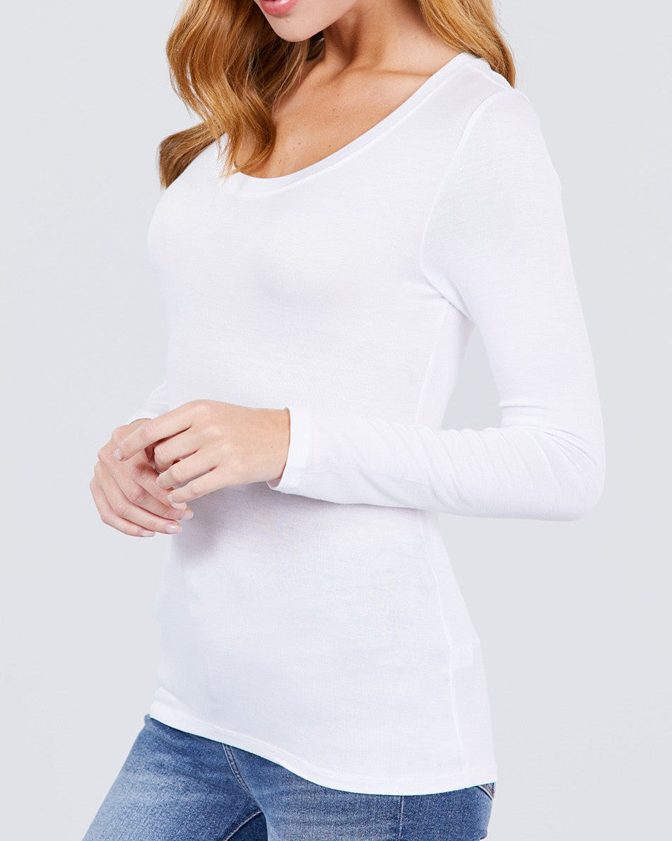 Woman wearing a white long-sleeve top and blue jeans on a light gray background