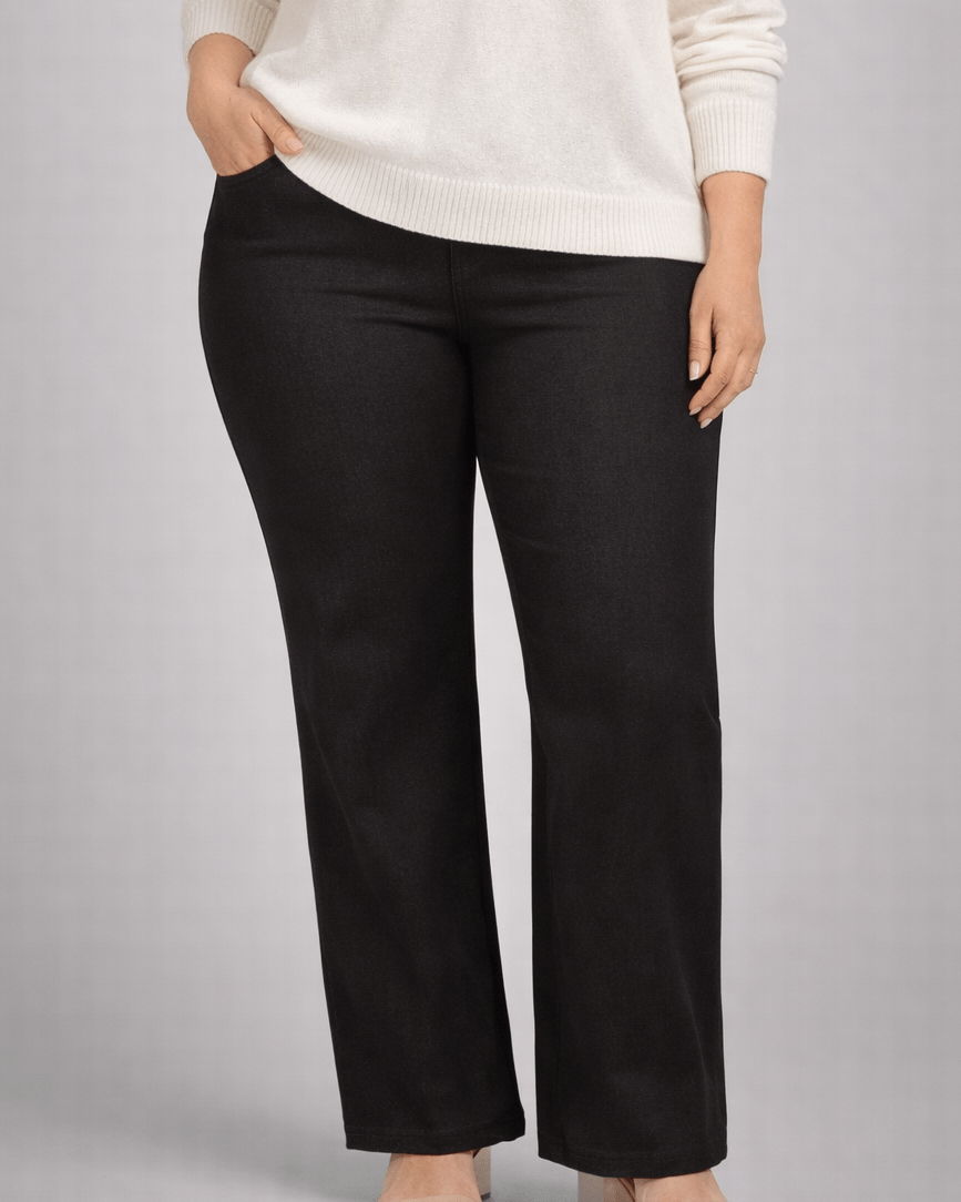 Person wearing a white sweater and black pants on a gray background
