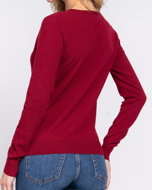 Woman wearing a red sweater and blue jeans on a white background